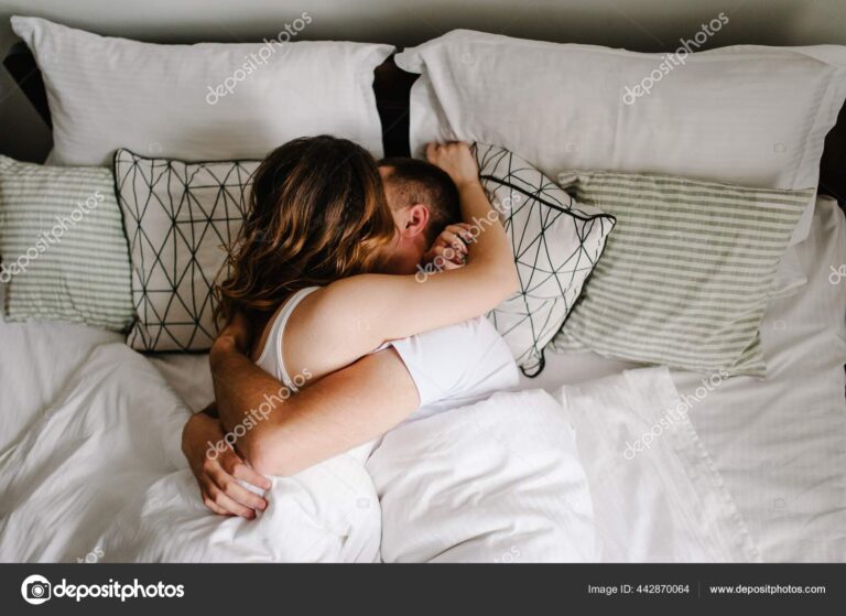 Loving couple lying on bed in the bedroom and kissing. The Valen