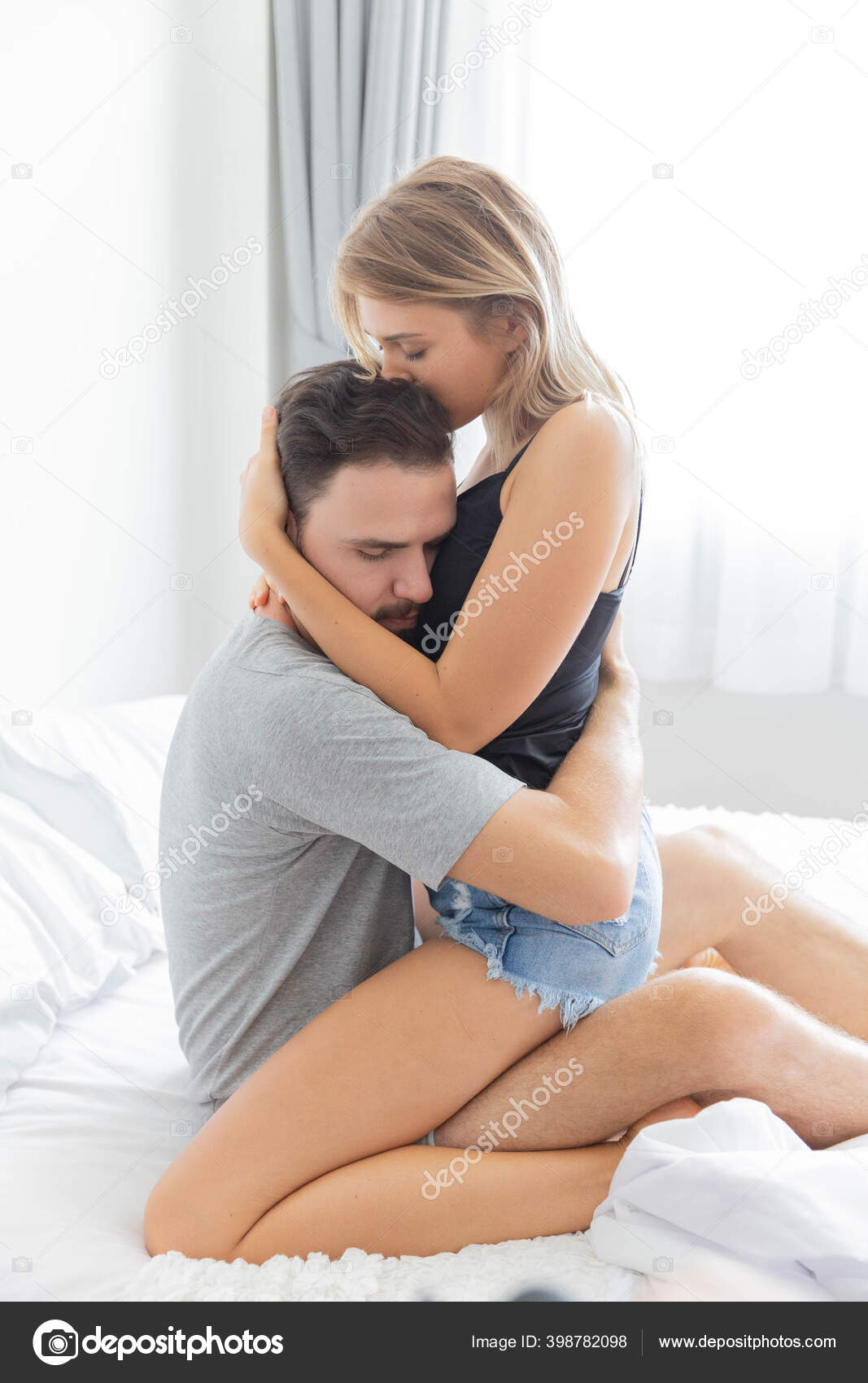 Passionate couple is hug and kiss on bed in their white bedroom